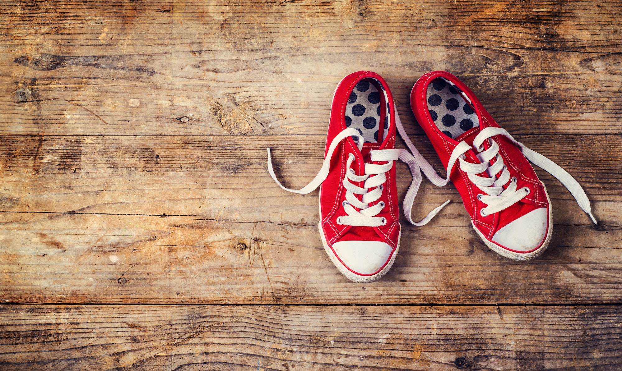 Red sneakers on a wooden floor