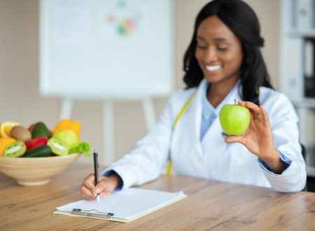 Cheerful African American nutrition adviser planning meals for client at clinic, copy space